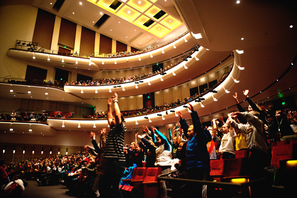 Audience members do the wave at a Physics Force show in Northrop Auditorium.